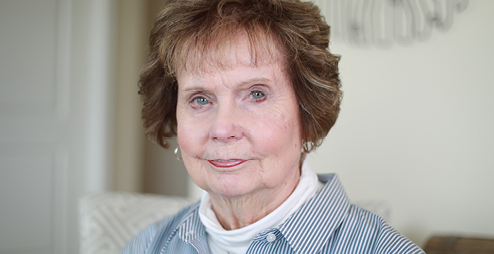 an elderly woman looking into the camera