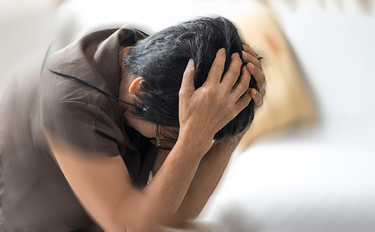 a stressed out woman with her hands on her head