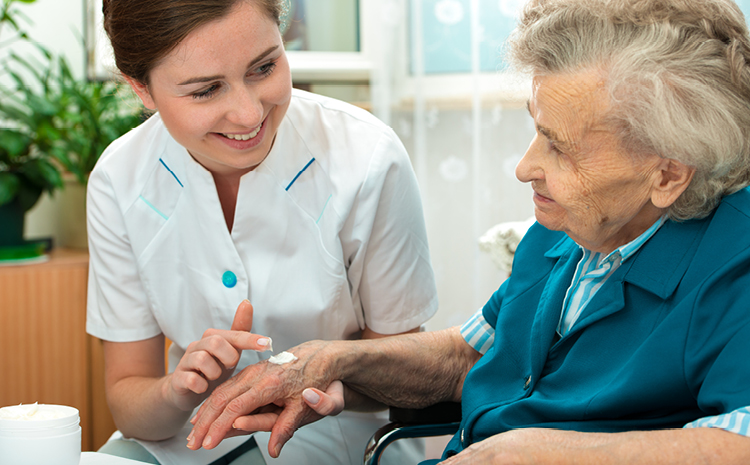 putting lotion on an elderly woman's hand