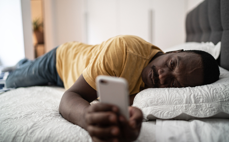 a man looking at his phone in bed