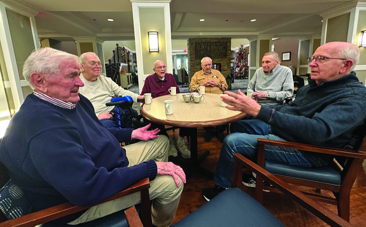 elderly men sitting around the table