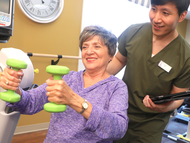 male senior fitness instructor assists senior female resident