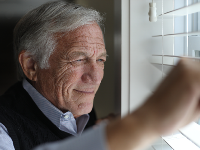 royal park place male resident looks out window pensively