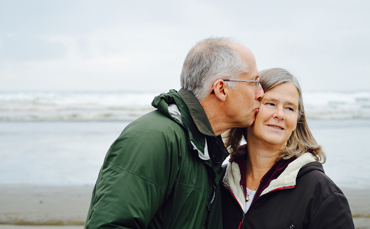 an elderly man kissing his wife