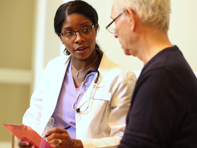 A doctor explaining something to her nursing home patient