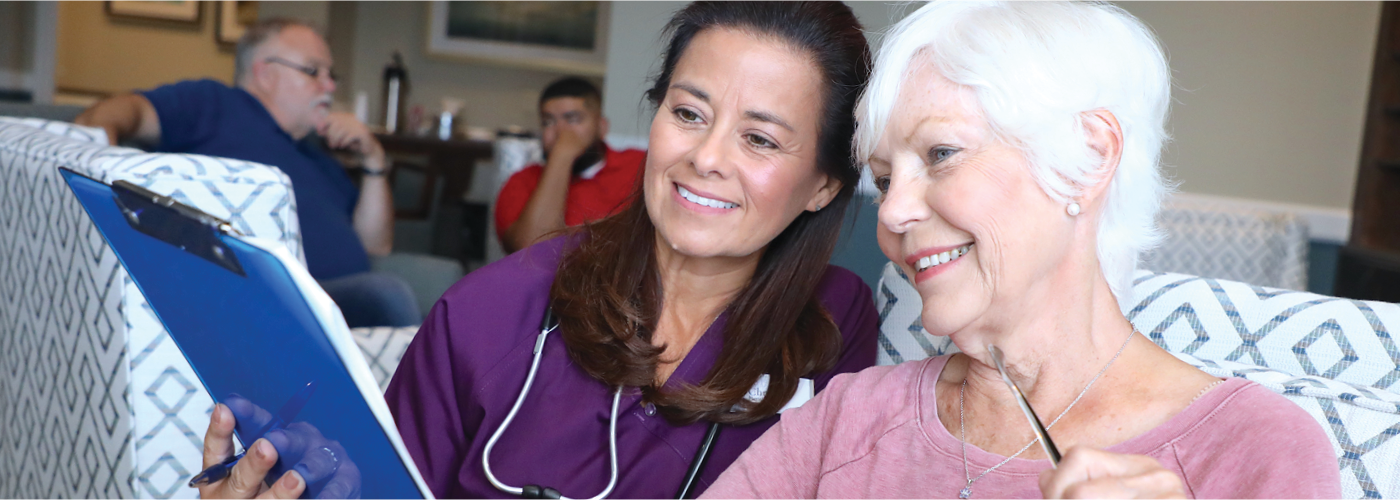 young female nurse shows senior woman information on a clipboard