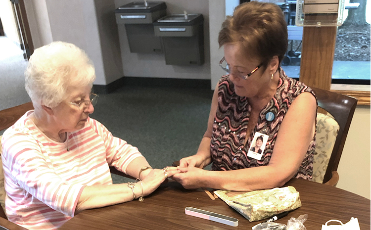 a woman doing an elderly woman's nails