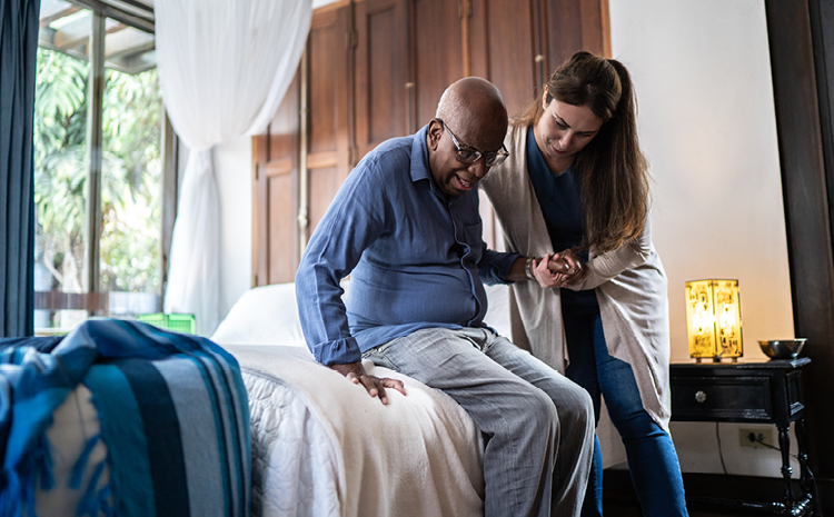 a healthcare worker helping an elderly man up