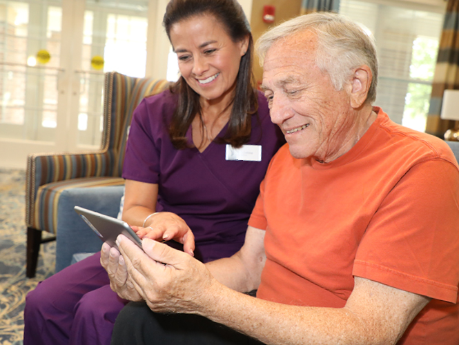 a cna helps a memory care resident with care plan at victorian village