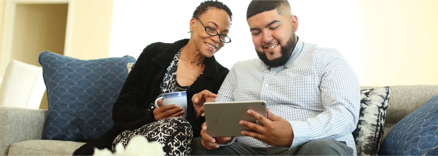 young man shows senior woman image on iPad