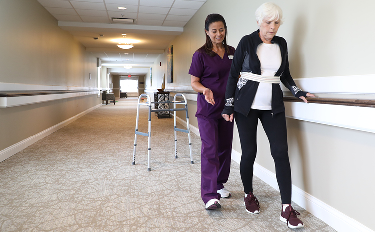 a healthcare worker helping an elderly woman walk