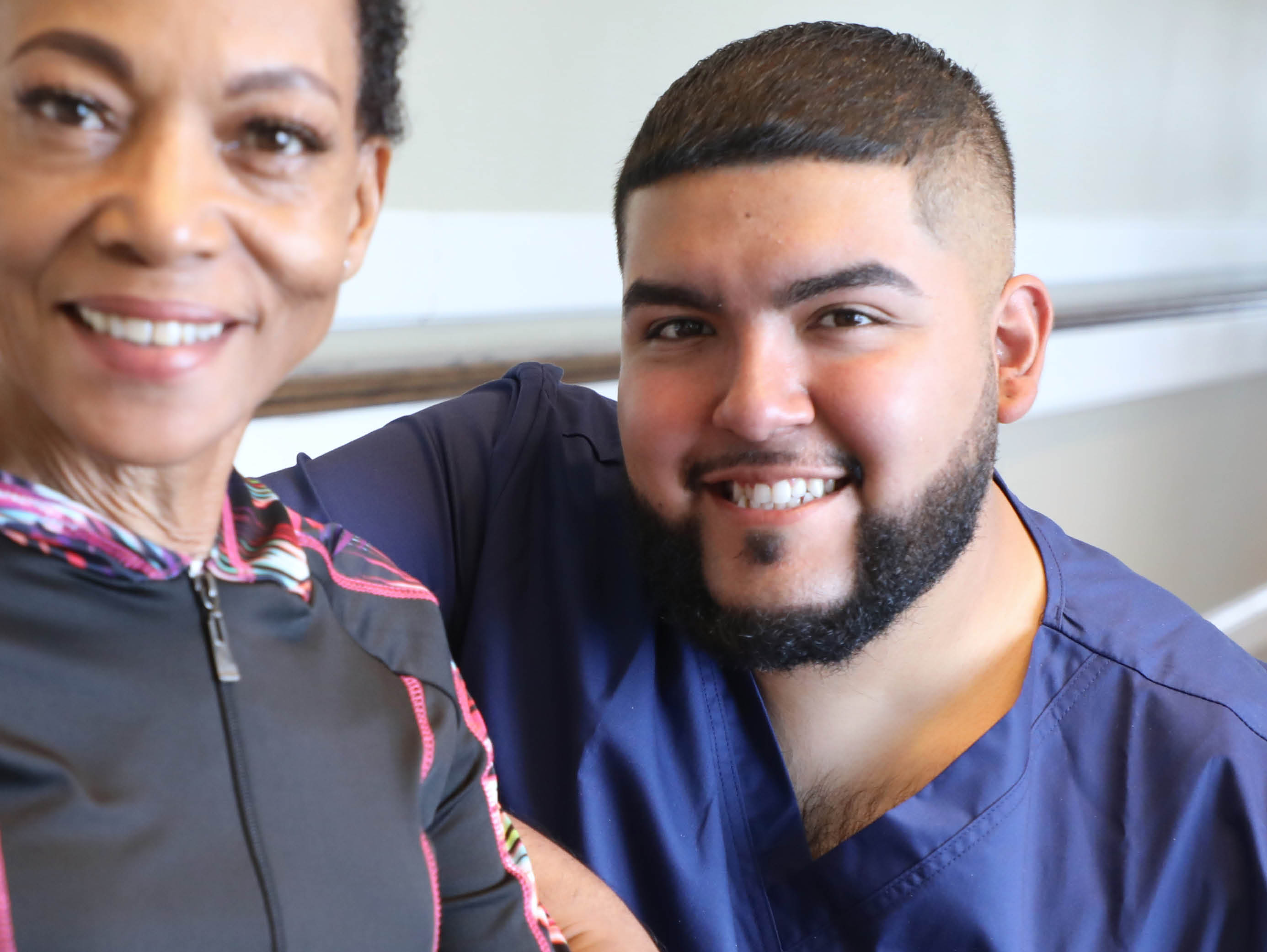 a healthcare worker and an elderly woman smiling