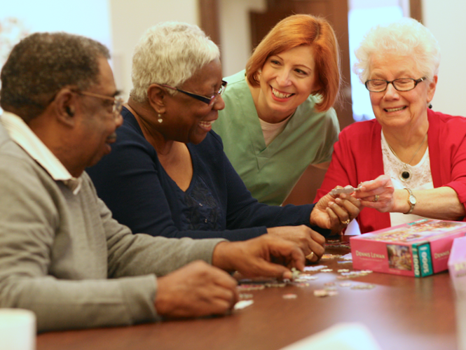 care partner assists nursing home residents at activity