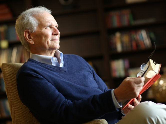 senior male resident attends spiritual service holding bible