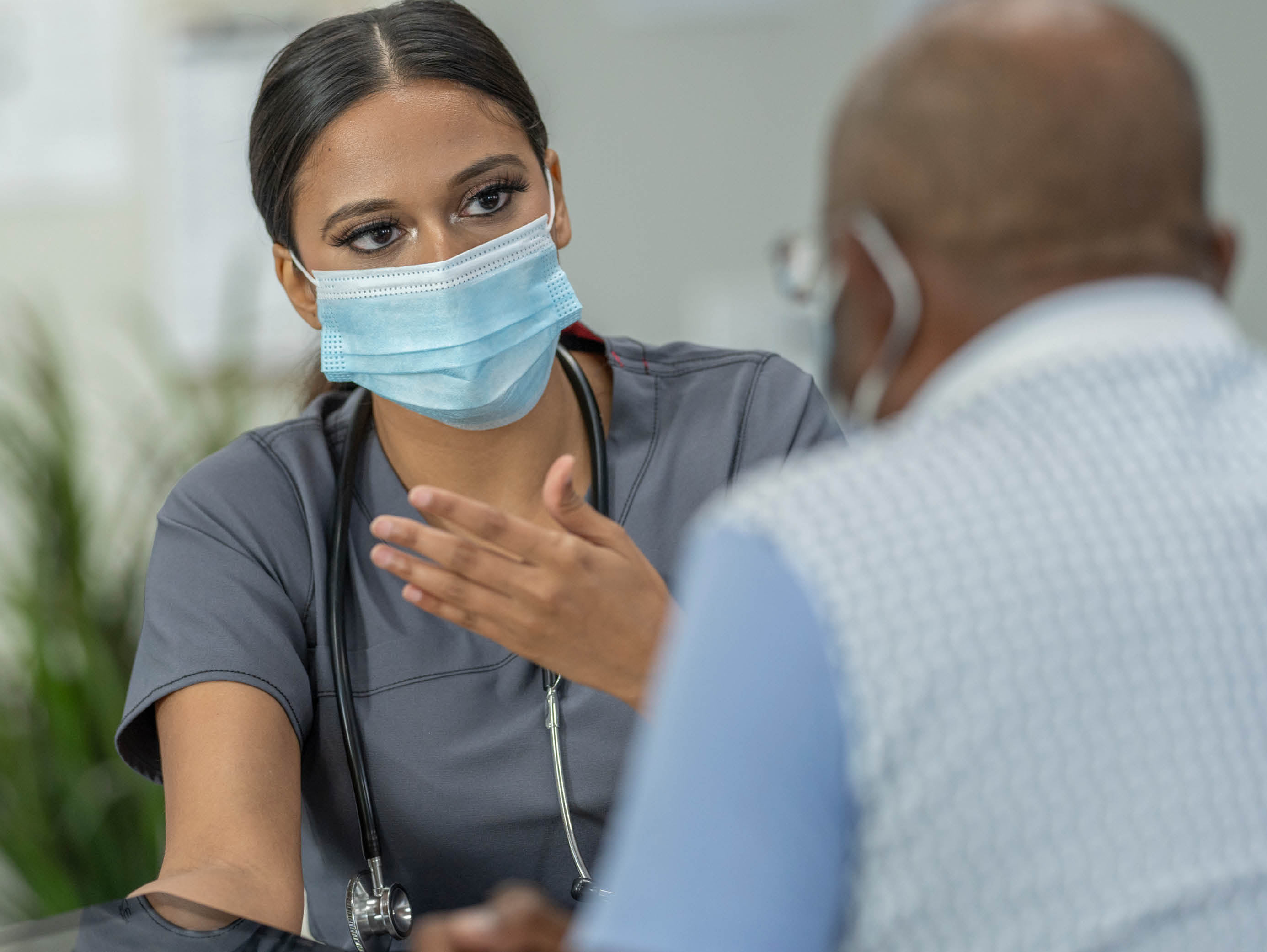 two people in surgical masks talking