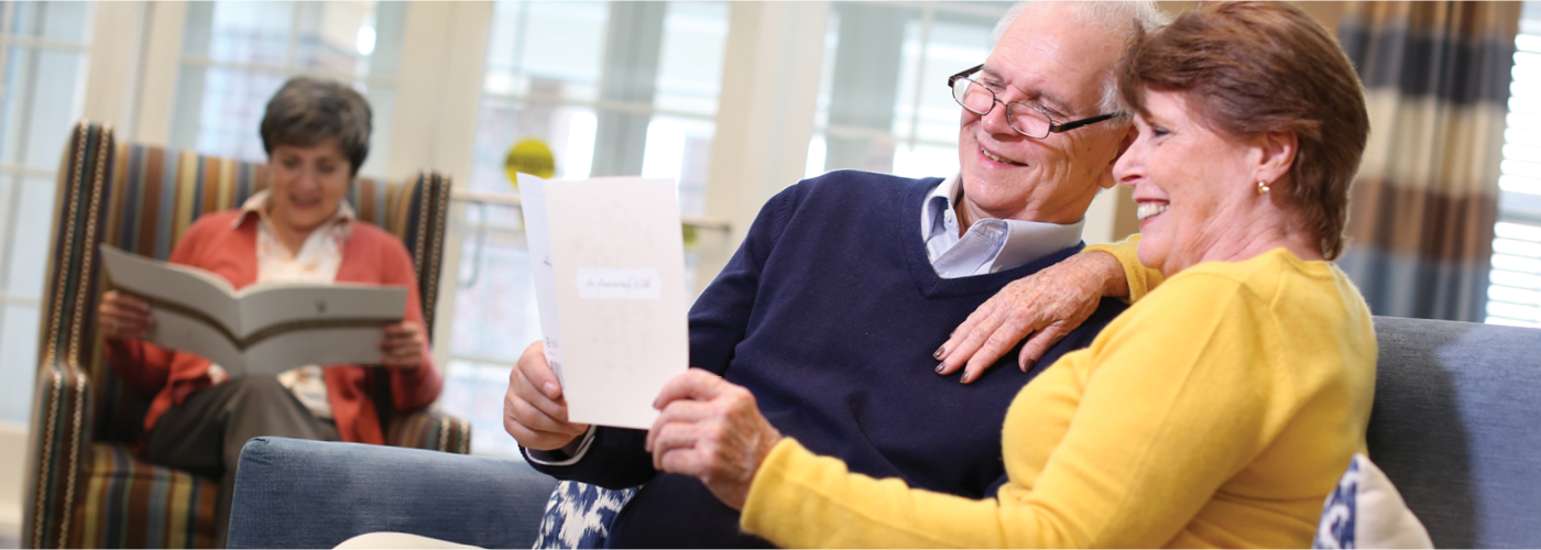 an elderly couple reviewing a brochure