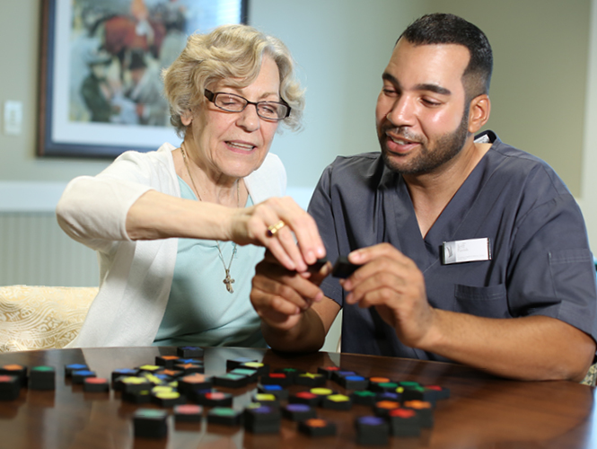 victorian village resident completes activity with her cna in memory care