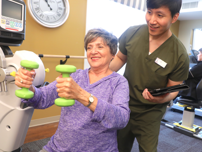 male senior fitness instructor assists senior female resident