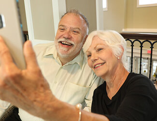 a senior couple takes a selfie enjoying independent living at victorian village