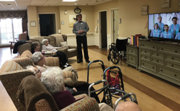 a pastor speaking to a group of elderly folks