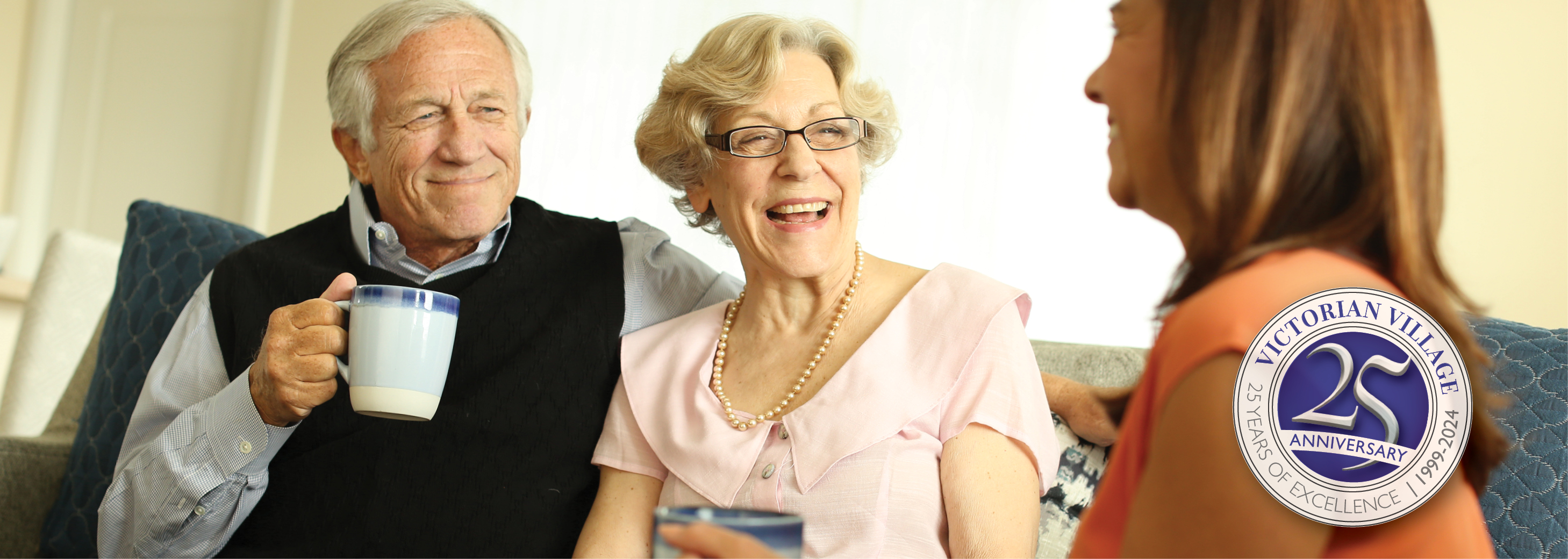 An elderly man and woman talk with their adult daughter at Victorian Village Senior Community