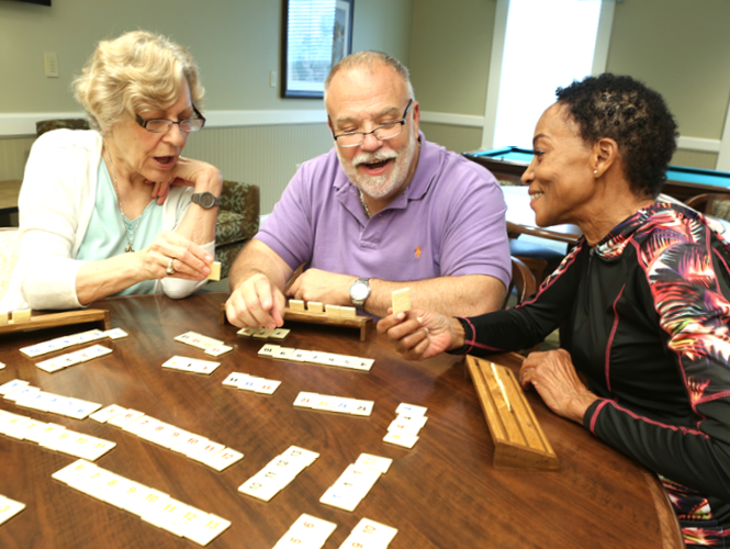 three senior residents playing rummikub at royal park place