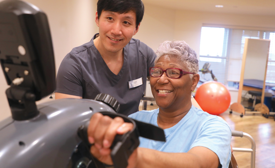 male therapist assists female rehab patient