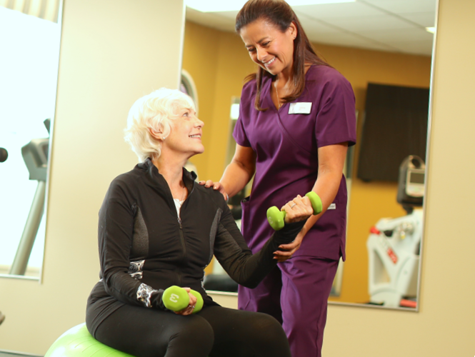 female senior park place resident works in gym with senior fitness staff