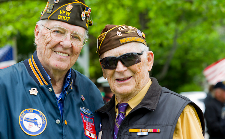 two elderly veterans smiling