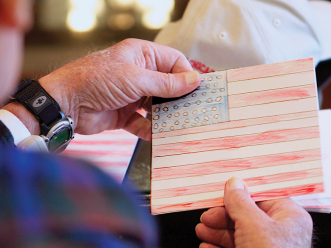 man holds child's drawing of American flag thinking about veterans benefits