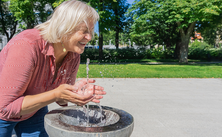 an elderly woman playing in a fountain