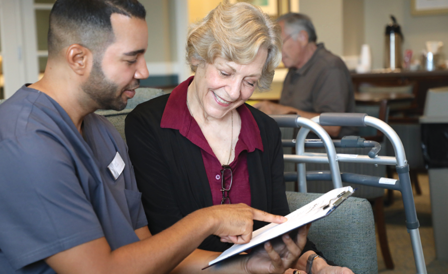 Male healthcare manager talks with a senior woman about her care