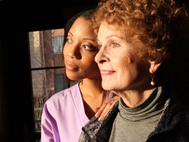 a providence hospice cna stands with one of her palliative care patients