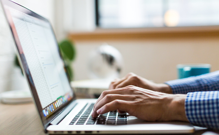 a man typing on a laptop