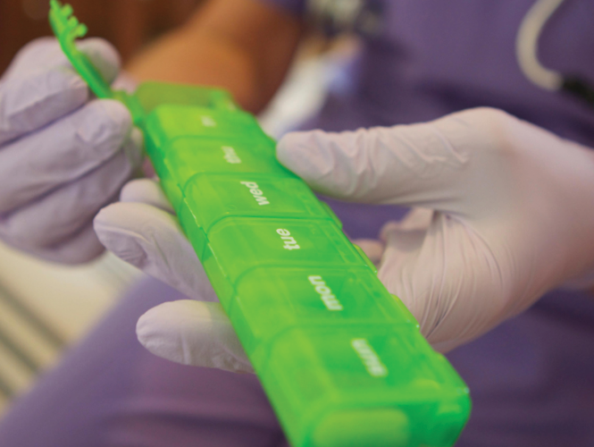 healthcare manager is ready to give medicine from pill box