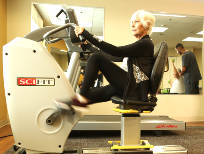 female park place resident uses exercise equipment in gym