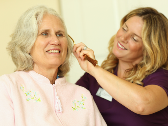 a CNA helps care for senior female's hair