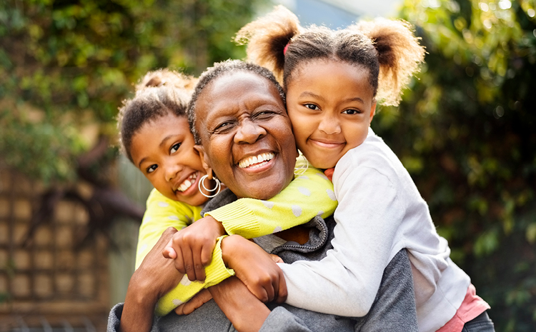 Grandchildren hugging their smiling grandmother