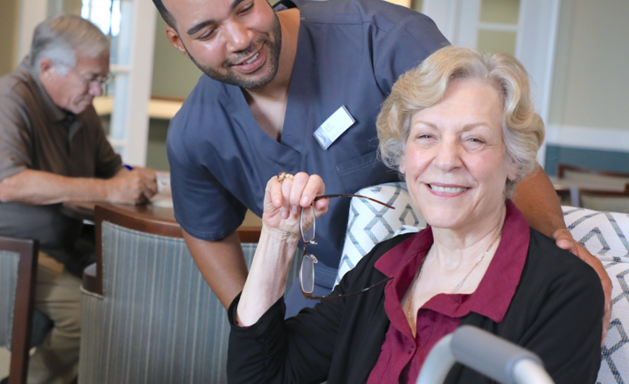 male cna attends to senior female resident