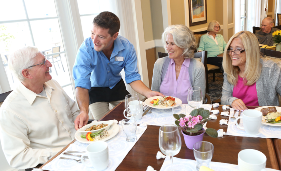 three senior park place residents are served restaurant-style lunch by waiter