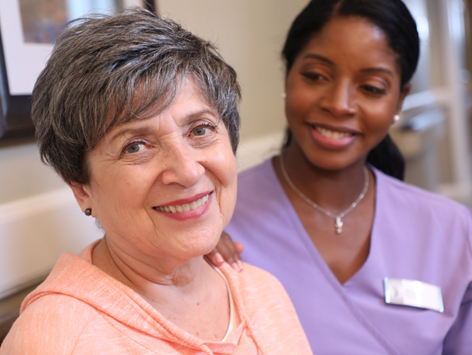 a healthcare worker smiling at an elderly woman