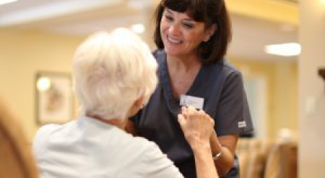 a healthcare worker helping an elderly woman