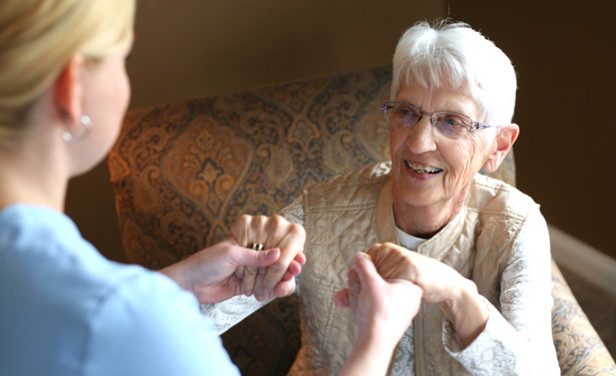 home healthcare therapist helps senior woman stand