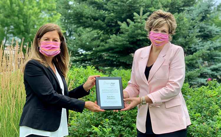 two women holding a plaque 6 feet apart